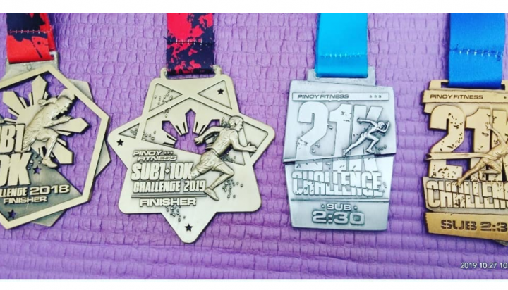 Photo of Ruby Aranas' Pinoy Fitness SUB1 10K and SUB2 21K Challenge finisher's medals